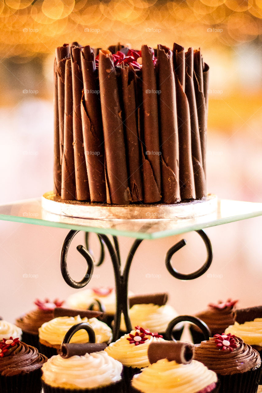 Sugar cupcakes and chocolate cake with lights in the background. Love the romantic feel of this image.