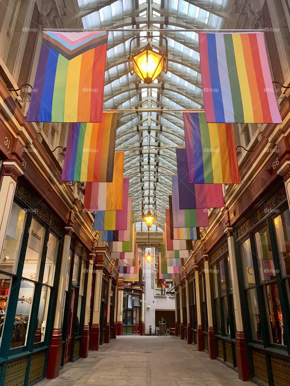 Central perspective of Leadenhall market in London, with colorful peace flags and store arcades 