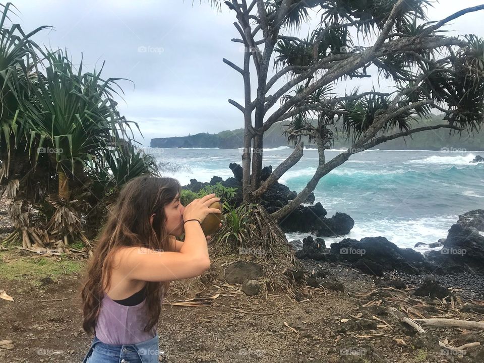 Drinking from a coconut in the shore of Hawaii.