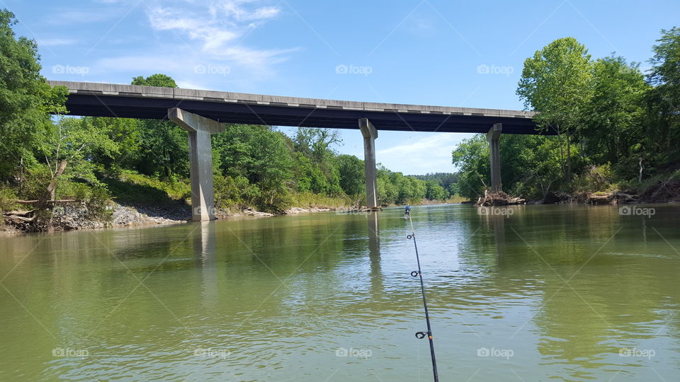 Fishing on the river with big bridge.