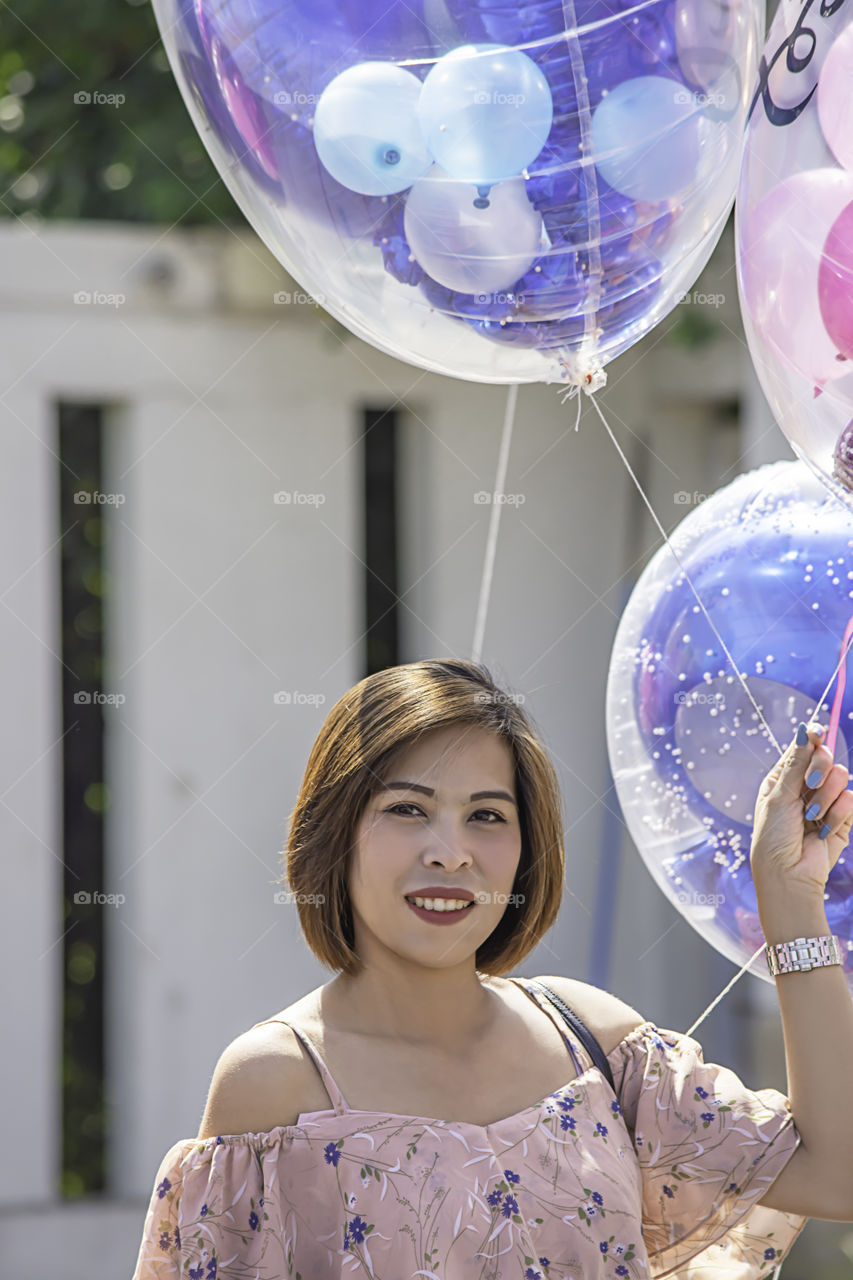 Asean Women are holding a balloon in hand.