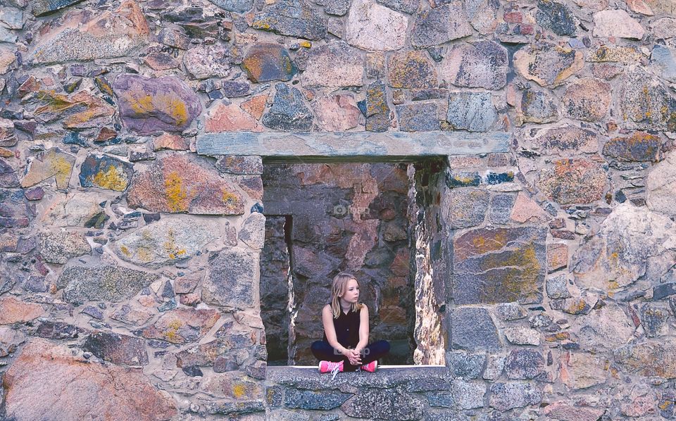 Girl sitting. Girl sitting in a window of old ruins