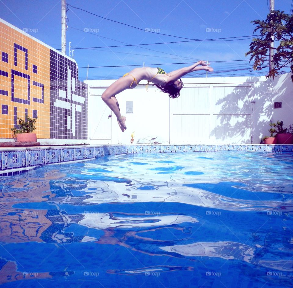 Woman jumping in swimming pool