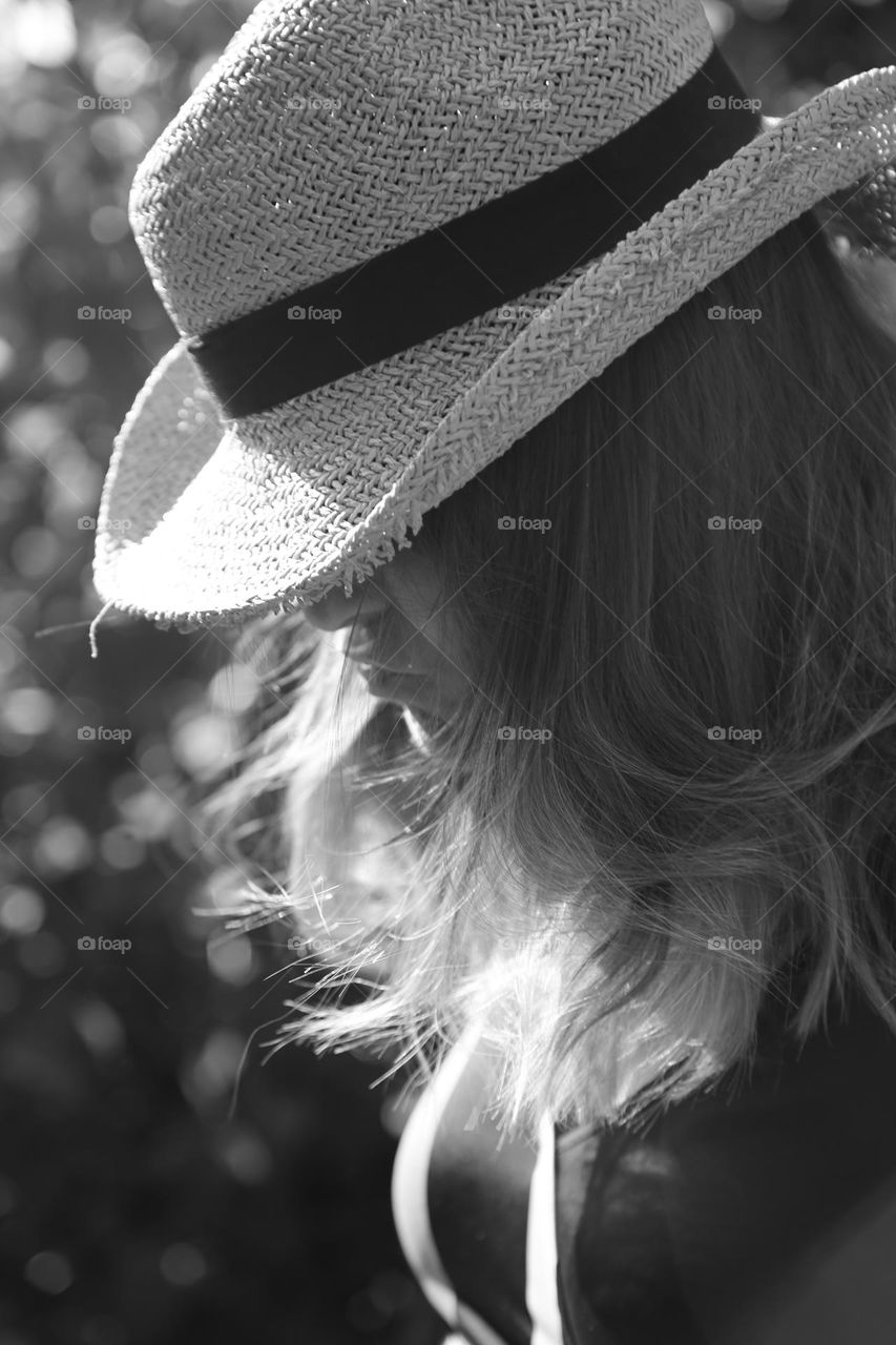 Woman with brown hair wearing a straw hat 