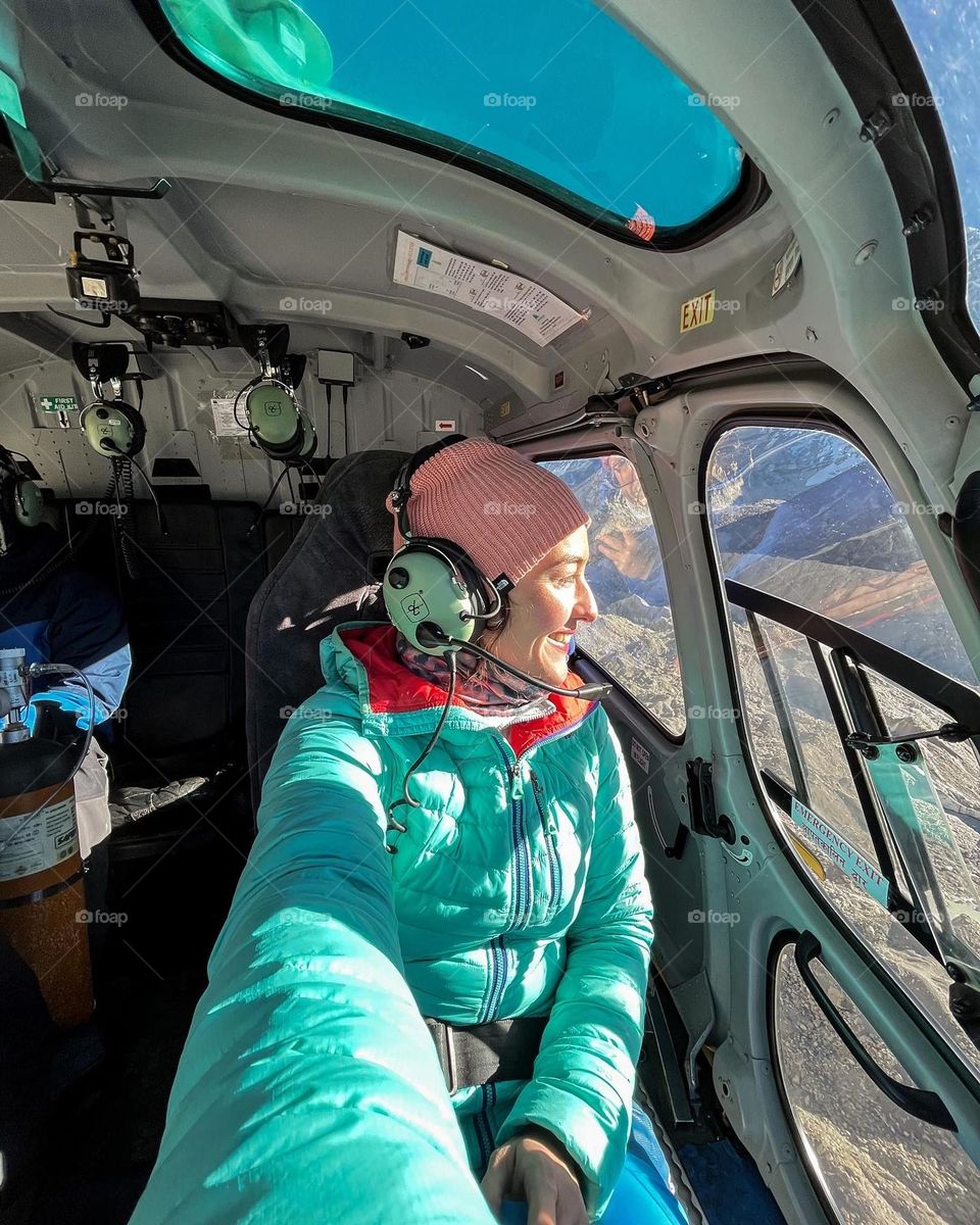 Woman being on a helicopter and flying over the Kumbu glacier while being on trip in Nepal.