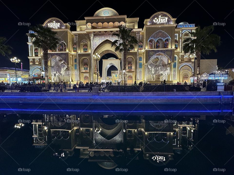 A magnificent oriental building illuminated in the dark and reflected in the water