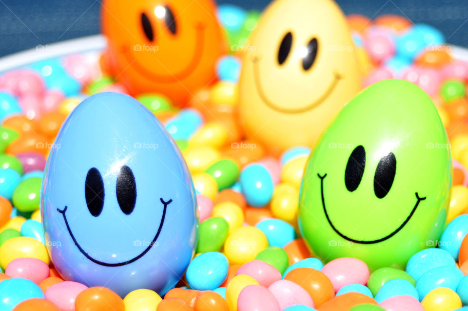 Smiling Easter Eggs and colorful candy. 