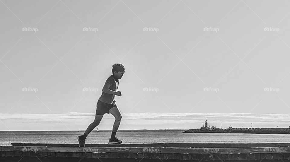 Born to run! young boy running along the coast.