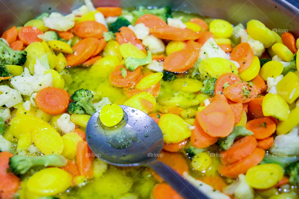 Thin sliced, steamed, colorful, nutritious veggies served in a bowl for dinner