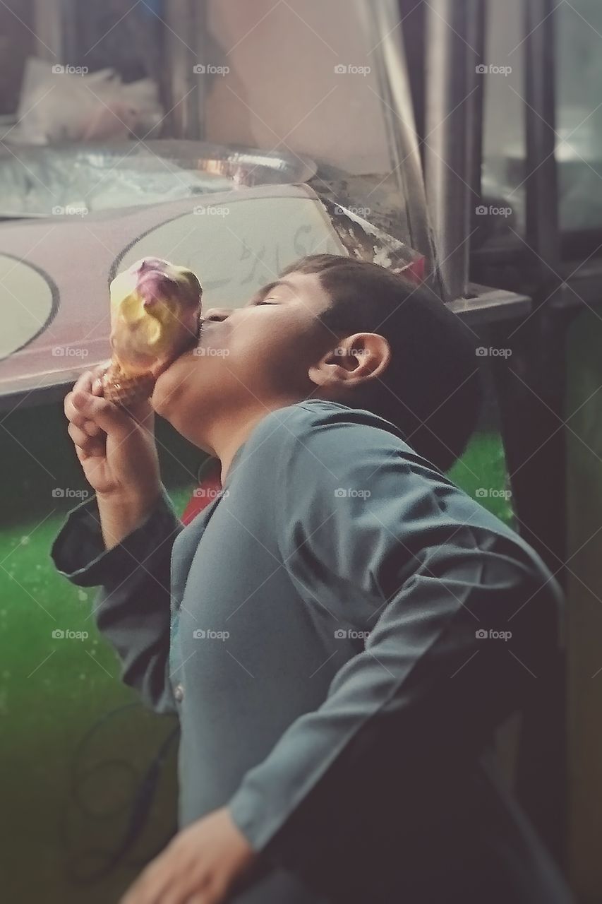 Ice-cream 🍦. i saw a boy busy in eating his Ice-cream, and i captured him without letting him know and then i showed it to his father