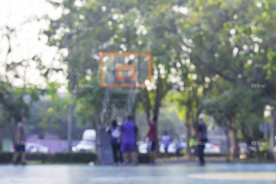 Blurry image of elderly men and women playing basketball in the morning.