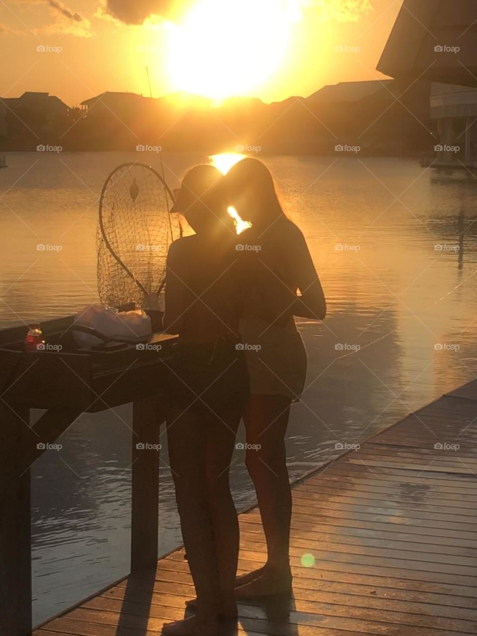 My niece and her friend fishing off the dock at sunset, baiting their hooks at the bay house in Texas. 