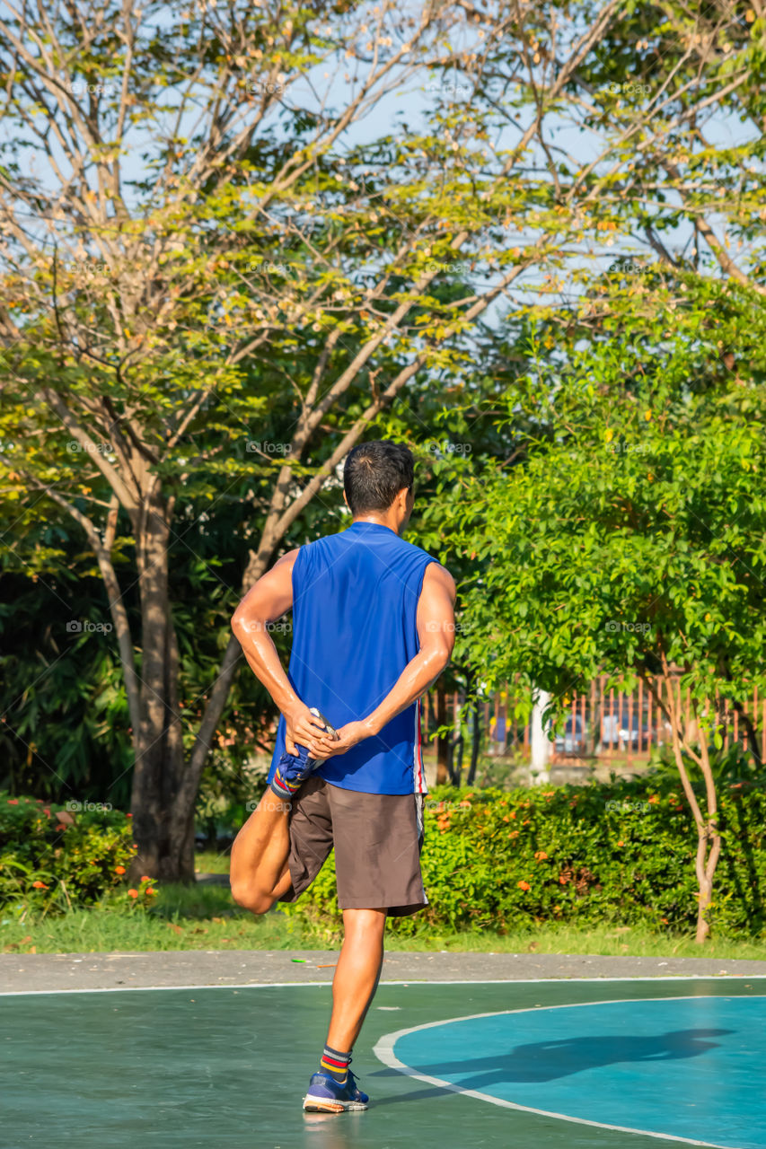 Asian man is warmed up before exercise in the park.