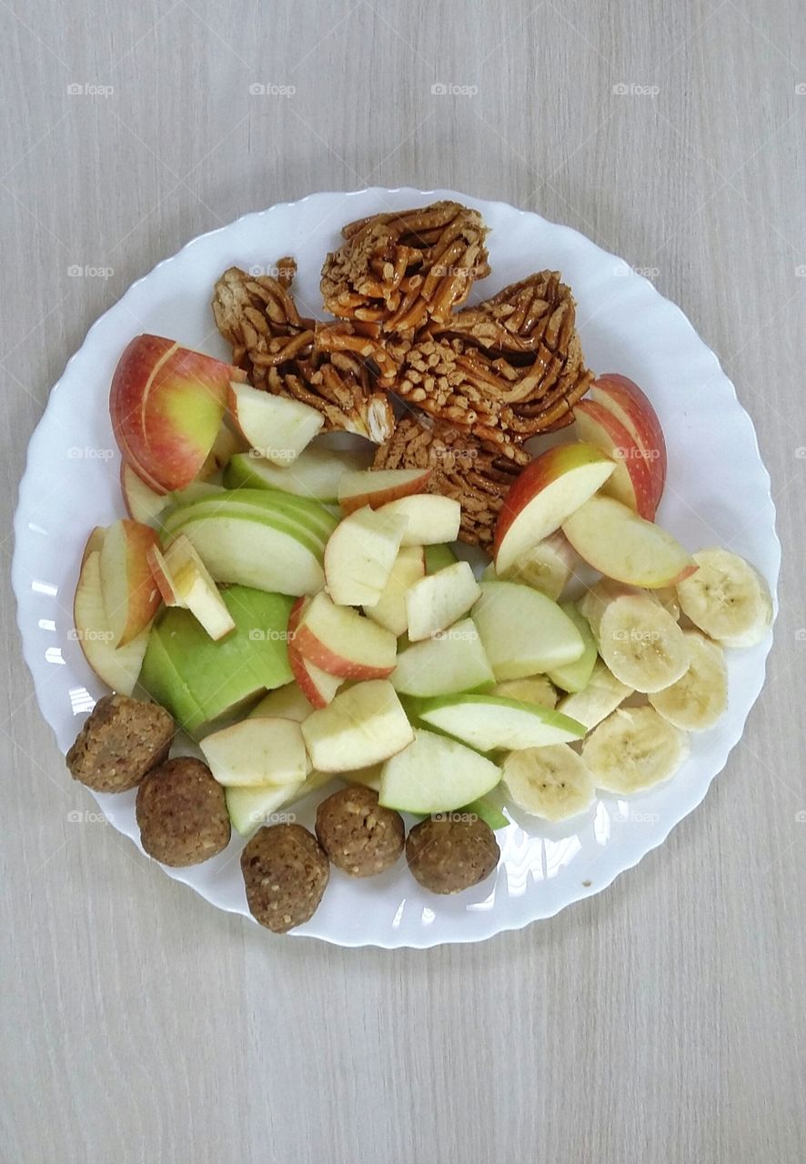 тарелка с фруктами и восточными сладостями на белой тарелке