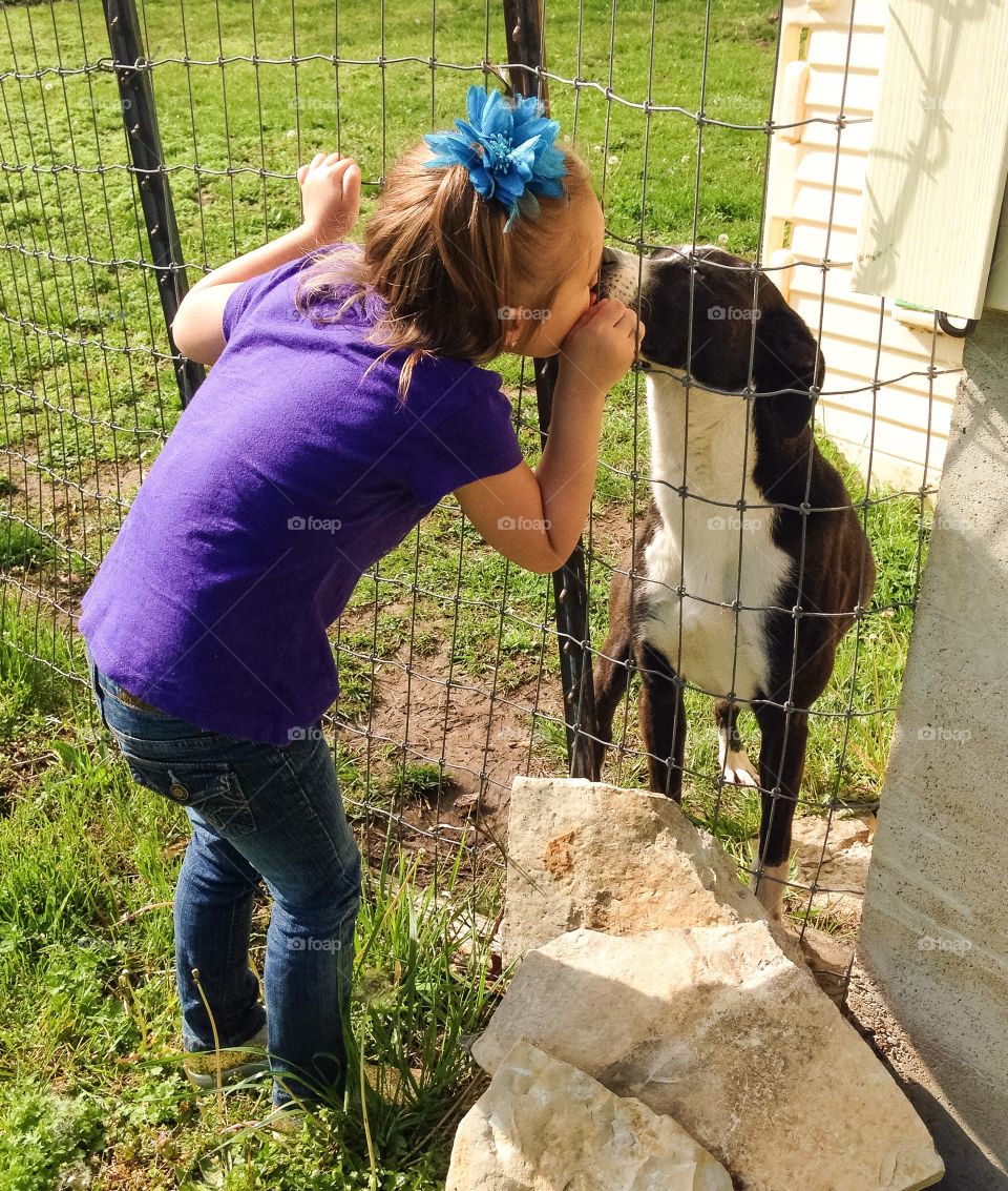 My baby girl kissing her dog