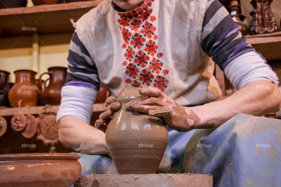 Learning pottery - man making a pot of clay