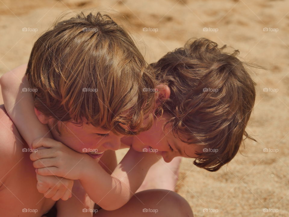 Happy brother playing in sand