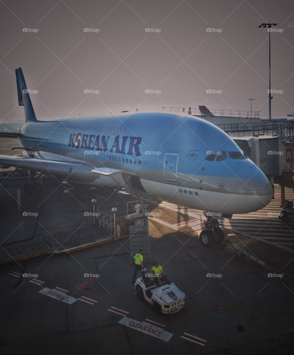 Korean Air Airbus A380 parked at the jetway at Sydney International Airport. Ground crew preparing the aircraft for the next take-off destination.