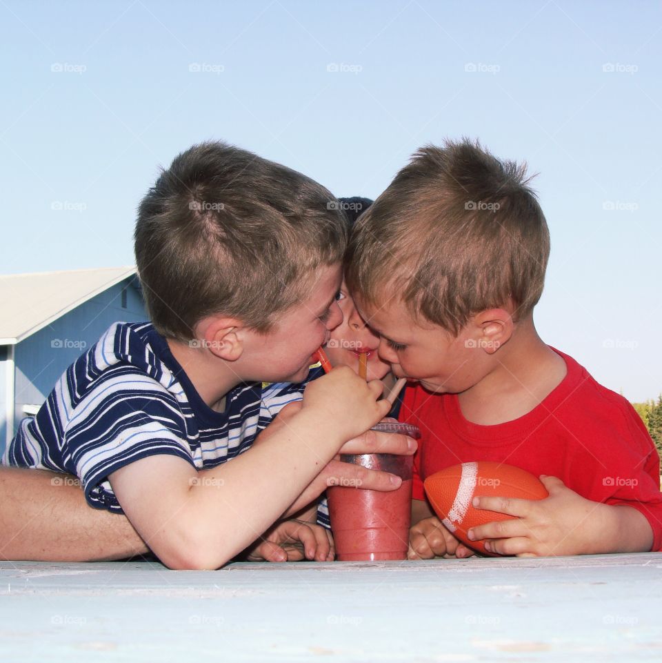Group of boy's drinking juice with straw