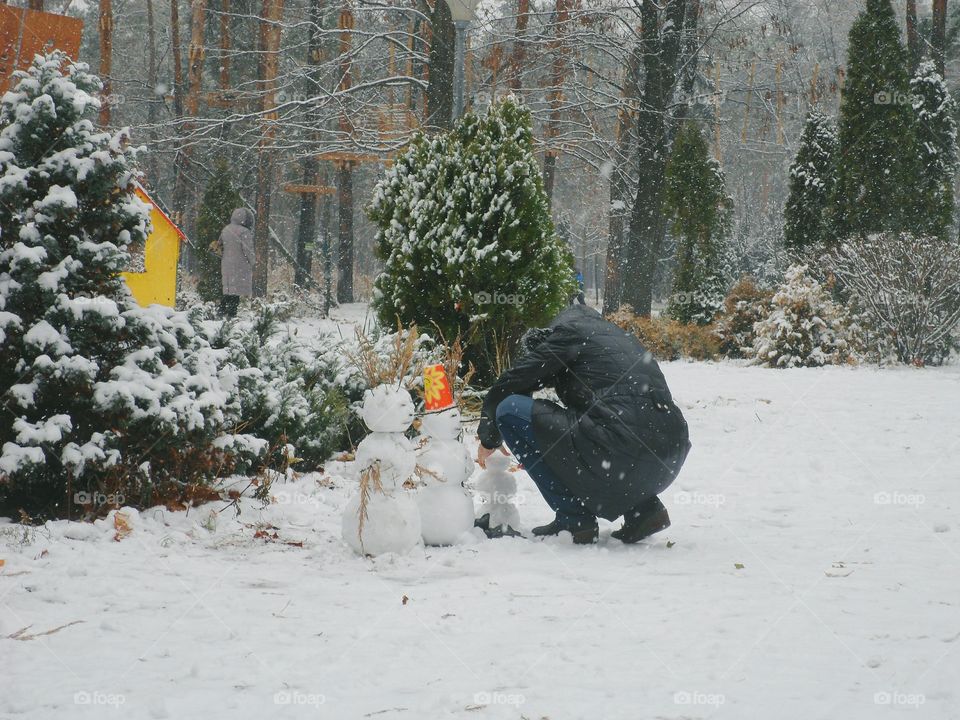 man sculpts snowman