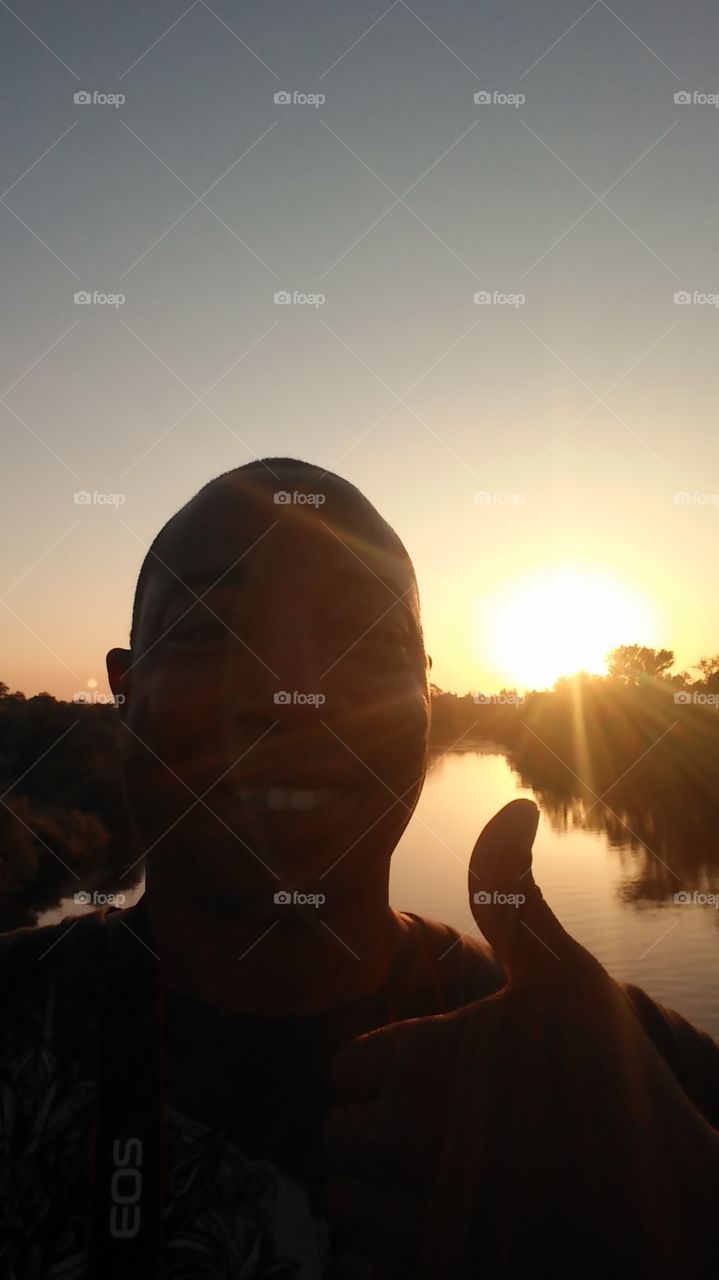 silhouette Sunset thumbs up with a smile