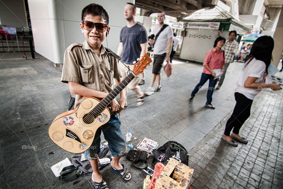 guitar boy. the boy play guitar for money 