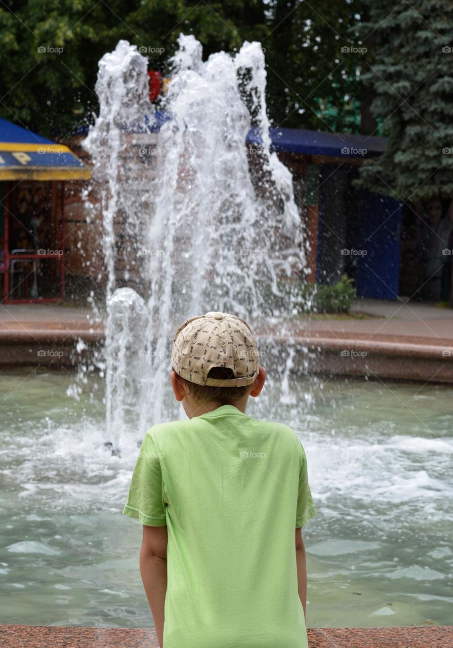 child boy and water fountain urban nature summer time