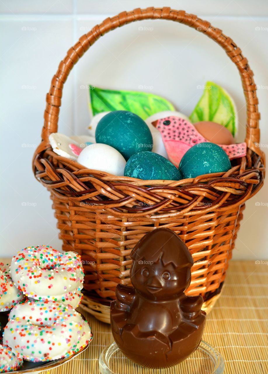 Easter colorful eggs in the basket and sweets spring holiday