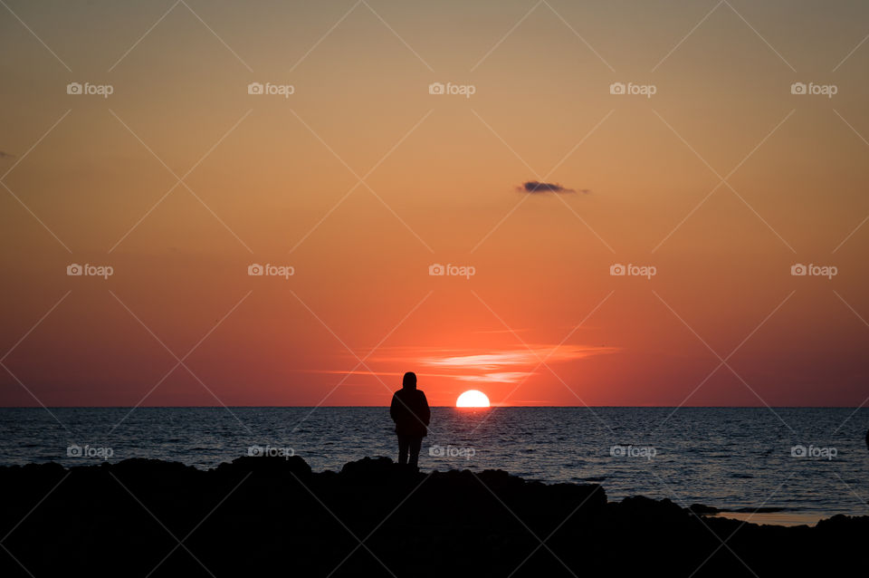 Lonely silhouette admires the sunset