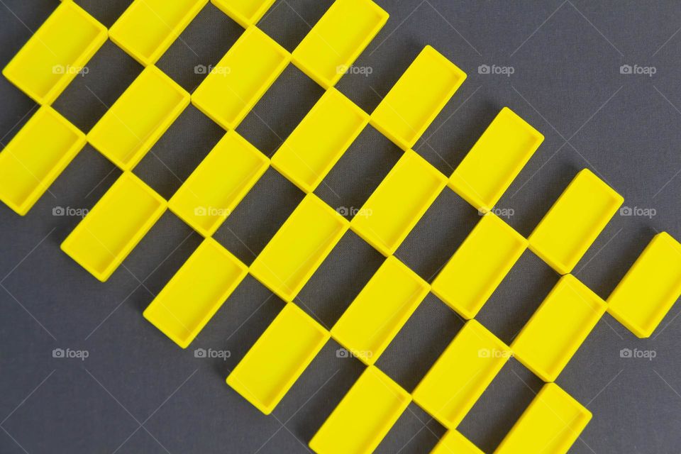 Many identical, repeating yellow rectangles on a gray background.