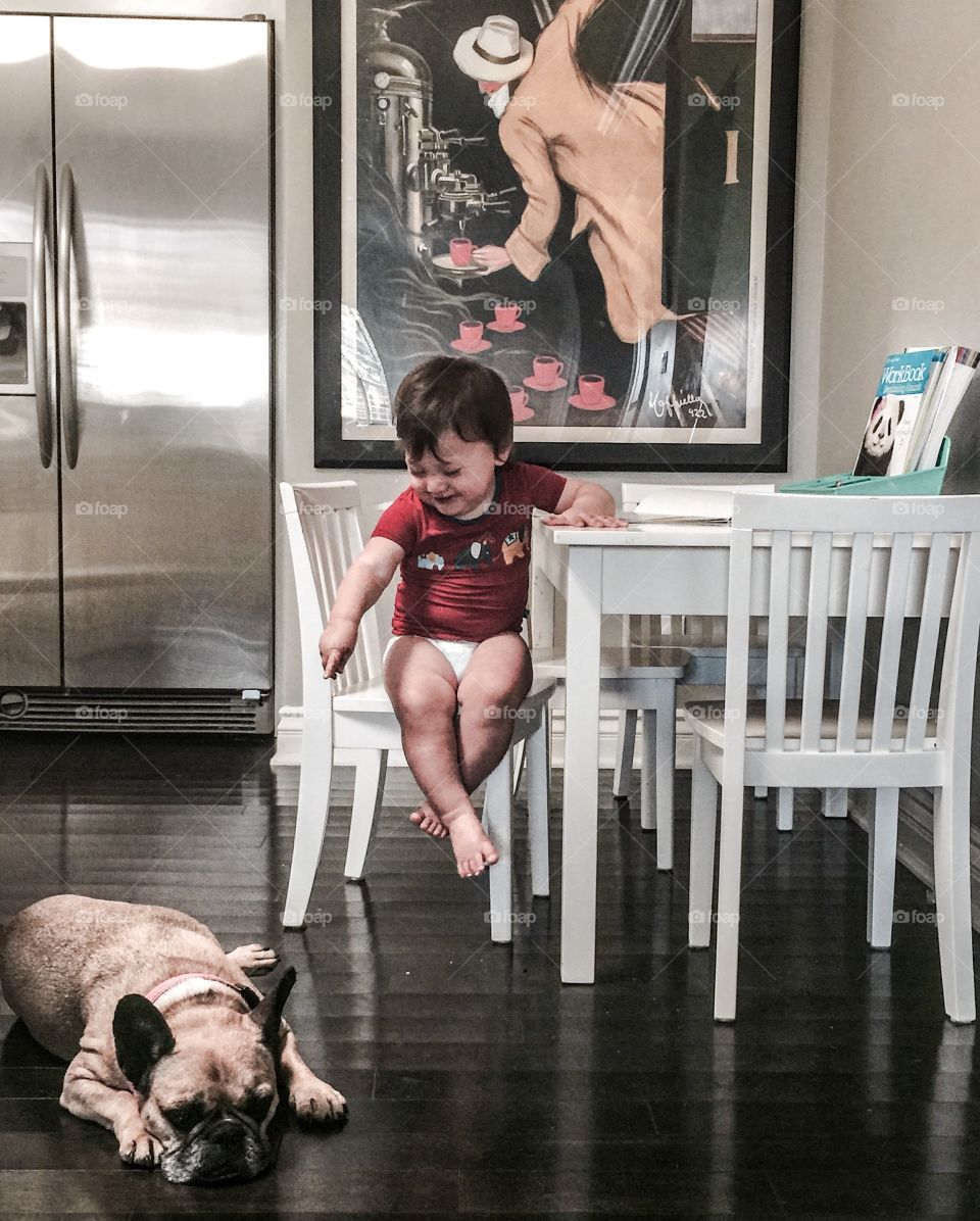 Smiling baby looking at his pet dog
