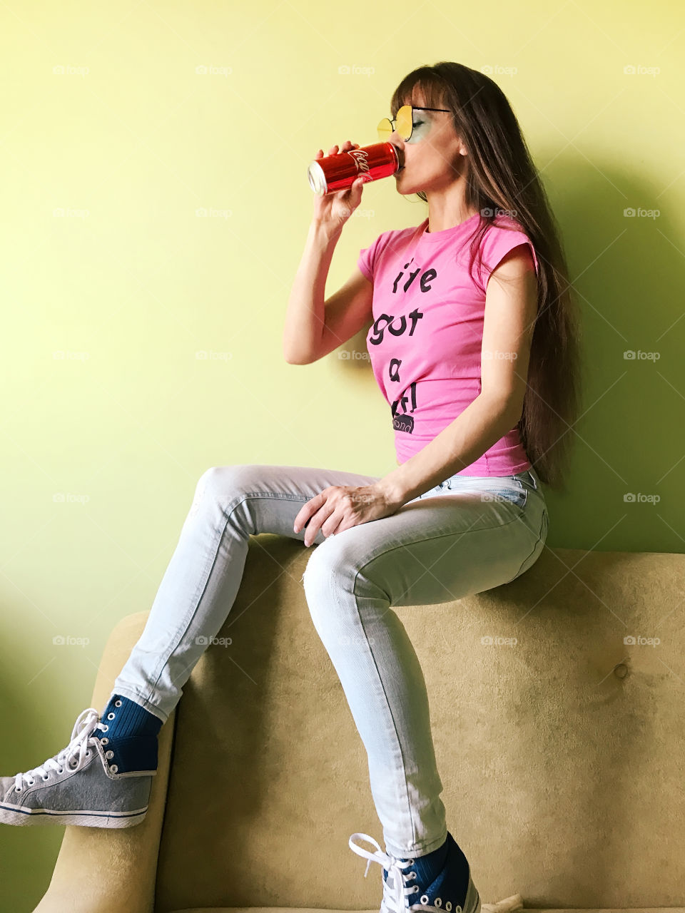 Young woman with long hair drinking coca-cola