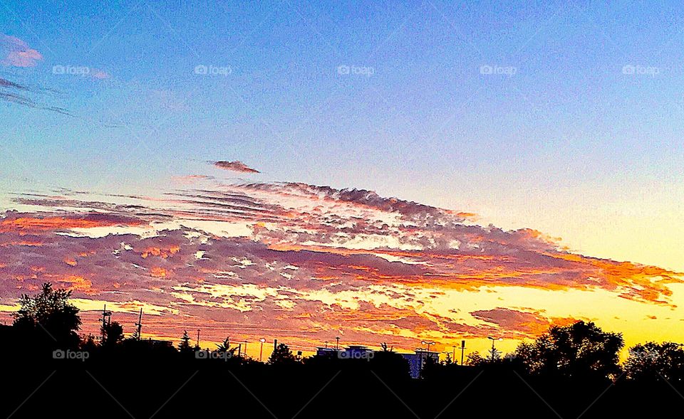 Majestic sunset with golds, reds, pinks, oranges, in blue skies 