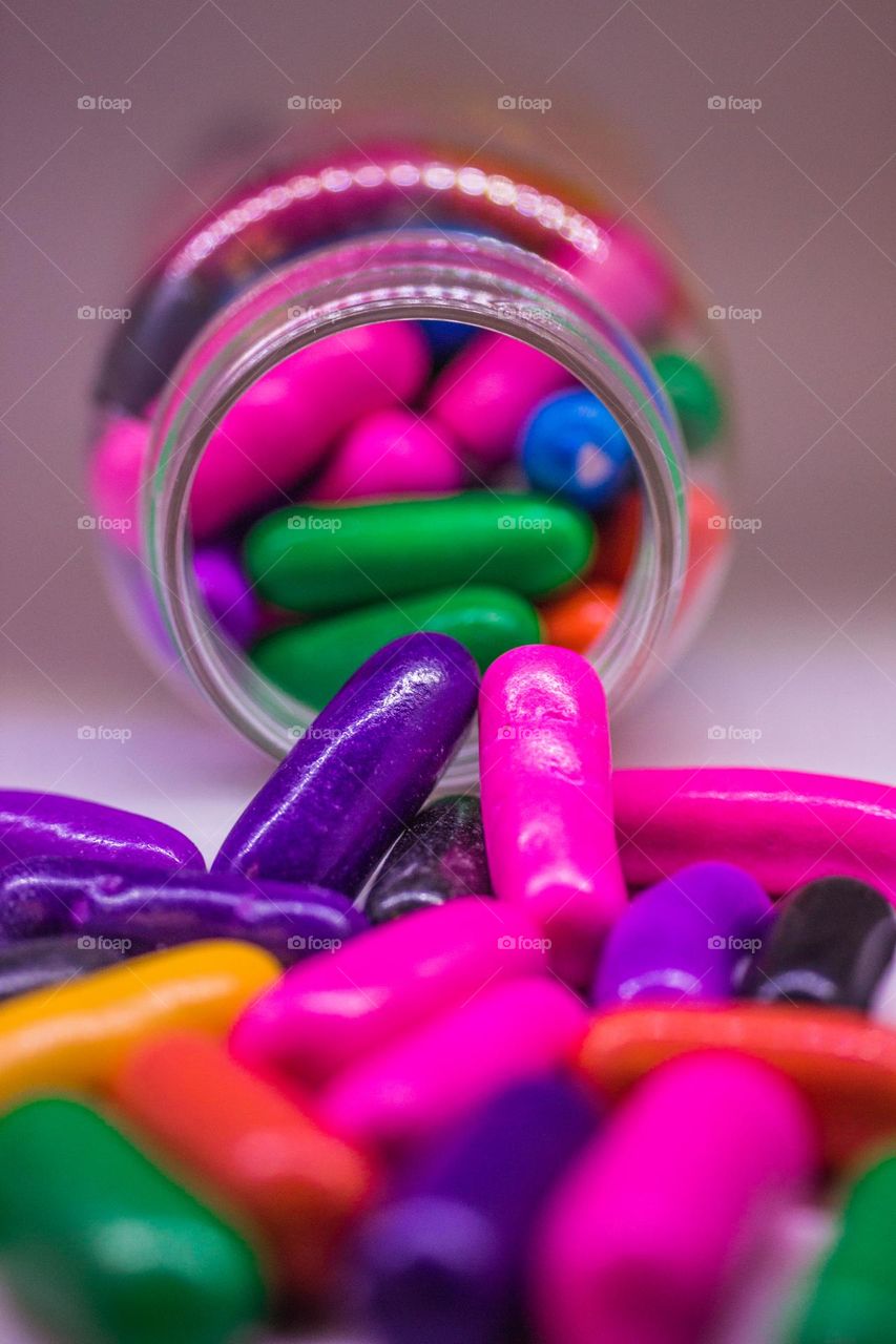 colorfully sweets falling from a bottle