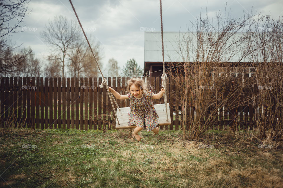 Little girl has fun on swing