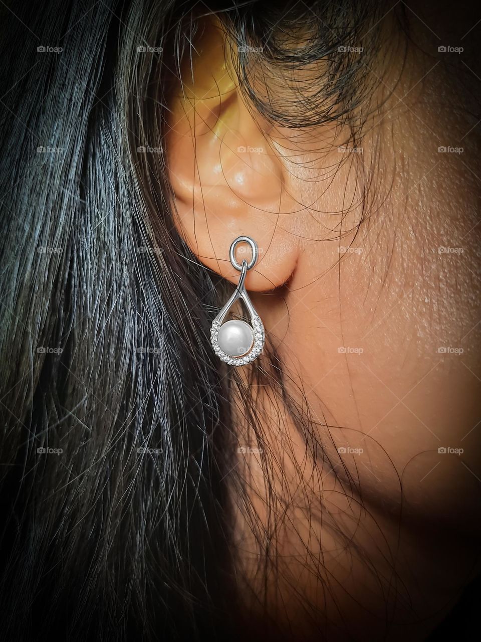 Wearing favourite jewellery. A silver earring with fresh water pearl and stones. The perfect party wear.