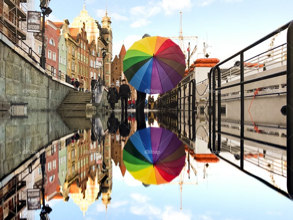 Reflection of person holding umbrella in river