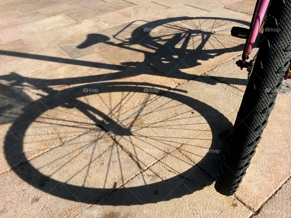 bike shadow on the sidewalk pavement