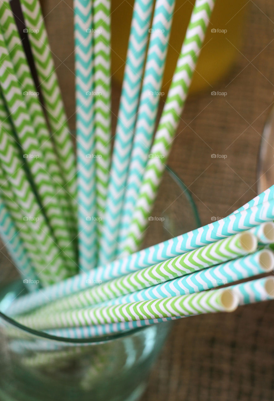 Blue and green chevron party straws in a clear glass