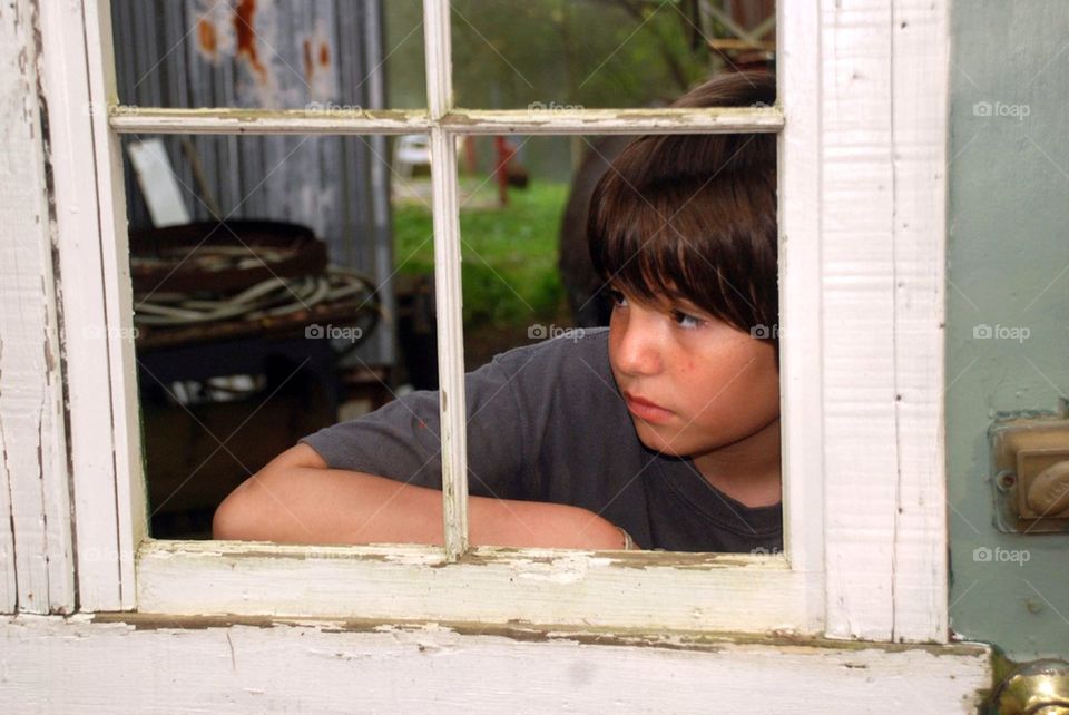Boy looking through window