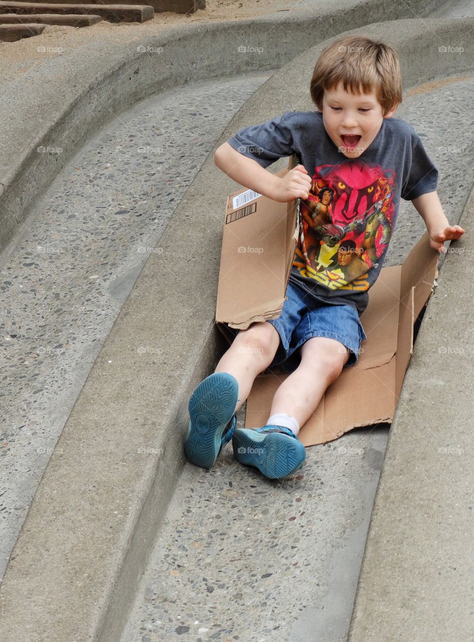 Boy On A Slide. Little Boy Riding A Fast Slide
