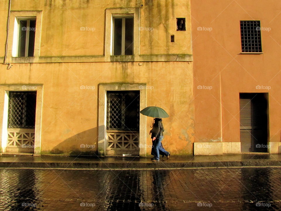 walking in the rain with umbrellas and is shadow