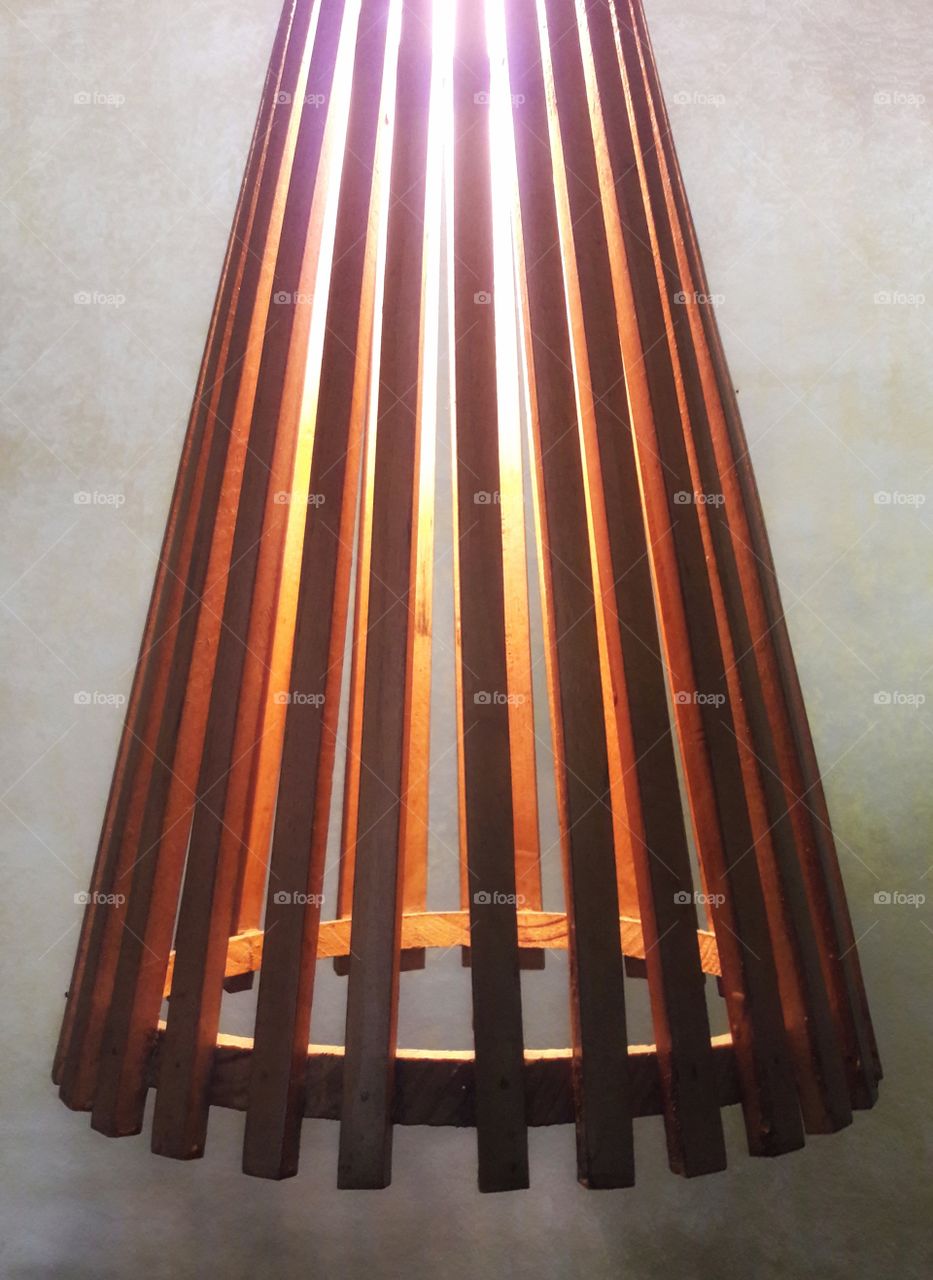 simple lamp shade wooden strips joined together with light bulb inside yellow