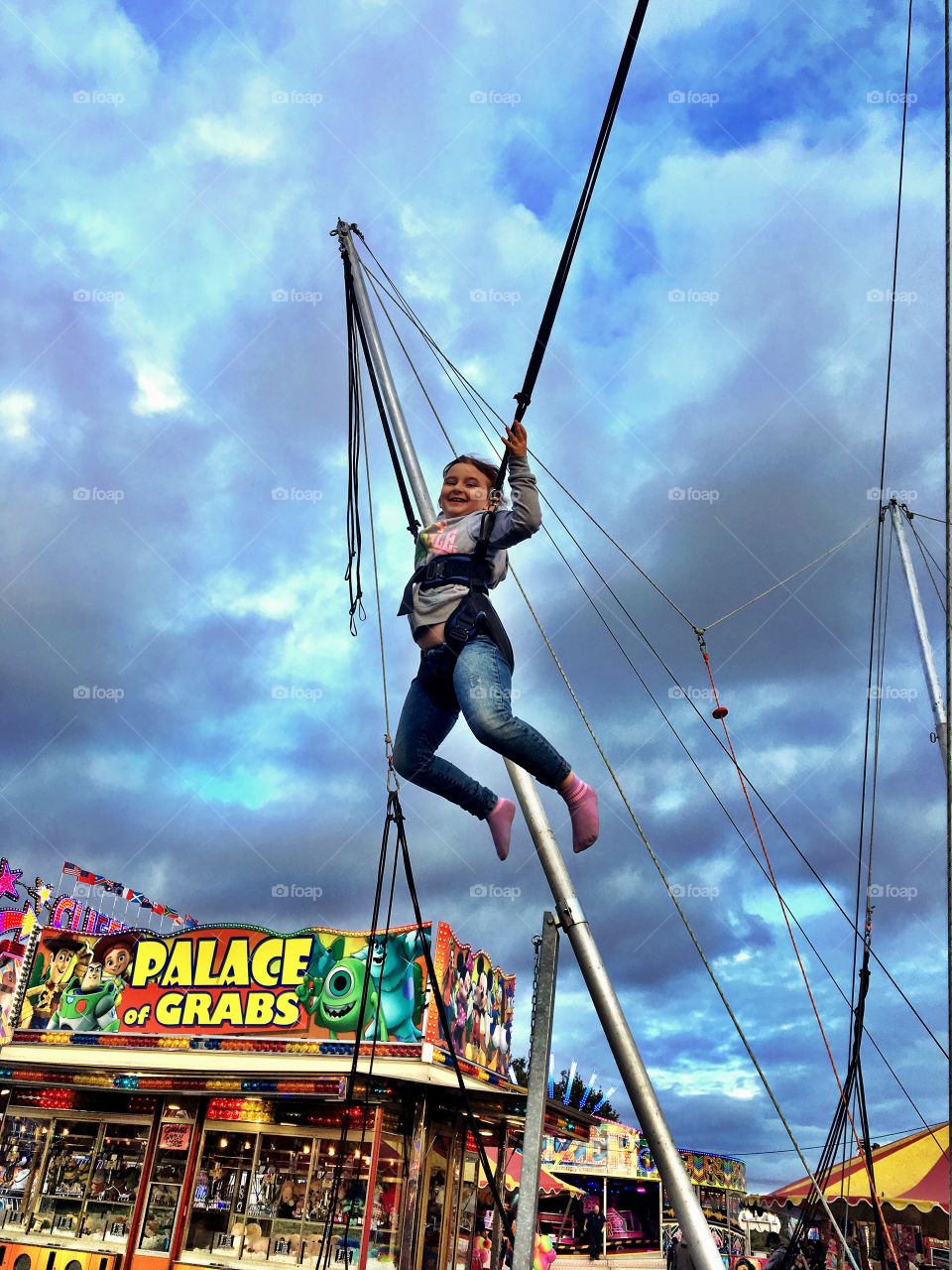 Child bouncing with bungees at the fun fair