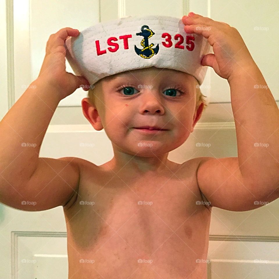 Little shirtless boy wearing sailor cap