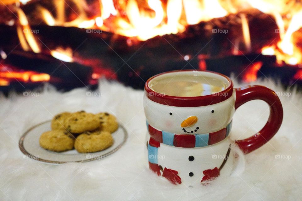 cappuccino with biscuits in front of the fireplace