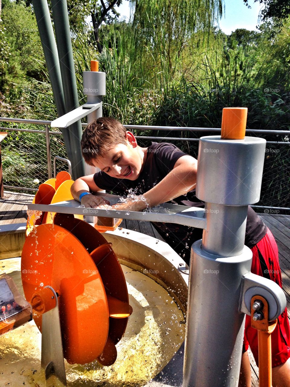 Summer playtime . Boy playing in an outdoor water play exhibit 