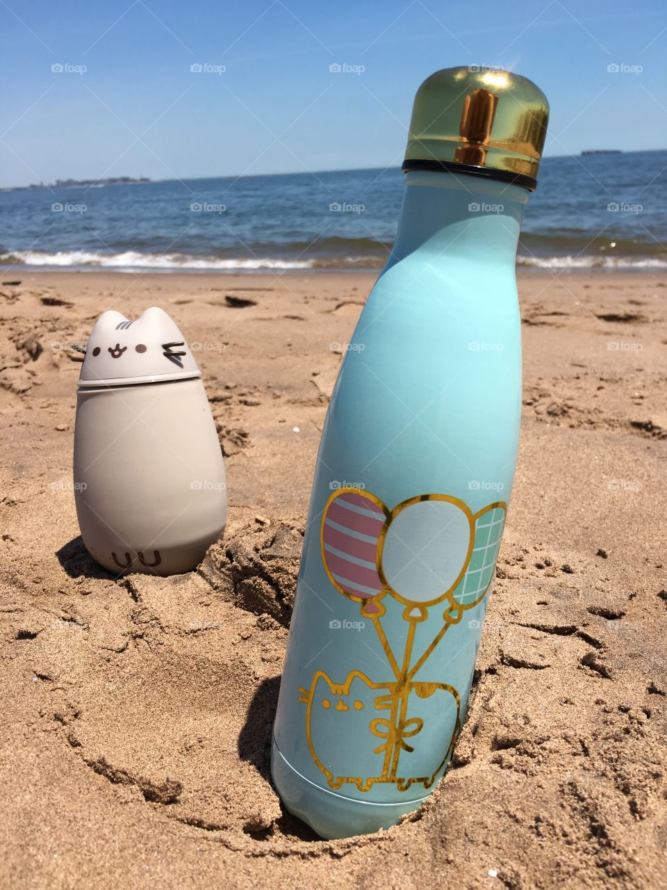 Two thermos in a sand on a beach