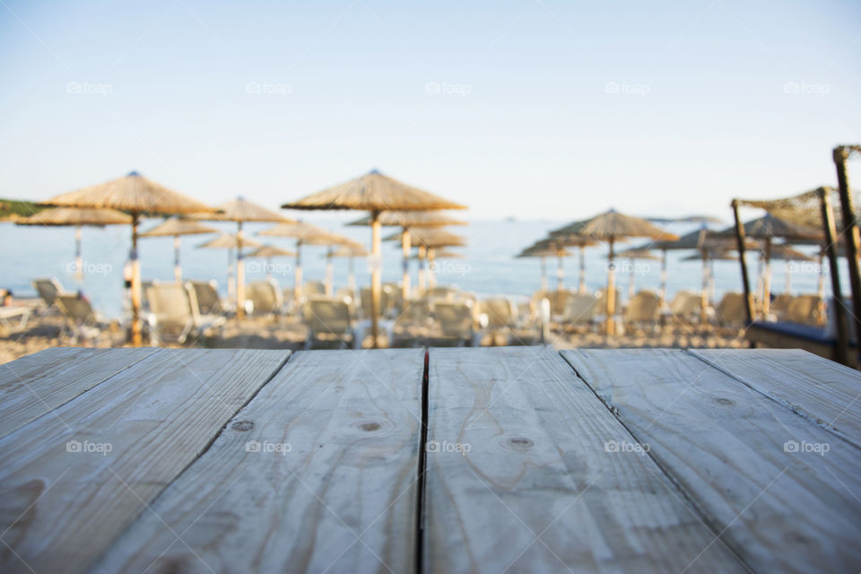 table on beach. wooden table in focus with beach in the background