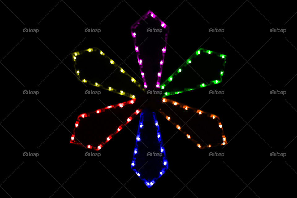 Night: This nighttime shot of a multicoloured Christmas light flower wreath was placed on a clean black background to accentuate the colours of the wreath. 